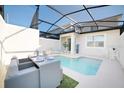 Relaxing outdoor pool area with a screened enclosure, dining set, and lounge chairs at 4973 Windermere Ave, Kissimmee, FL 34746