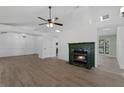 Open-concept living area featuring a fireplace, wood floors, and vaulted ceilings at 762 Lake Como Dr, Lake Mary, FL 32746