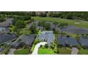 An aerial view of a single-story home near a pond and golf course, surrounded by lush greenery at 856 Bentley Green Cir, Winter Springs, FL 32708
