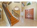 Grand foyer featuring a stunning staircase, chandelier, and decorative double front doors at 9128 Phillips Grove Ter, Orlando, FL 32836