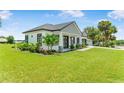 Landscaped lawn of single-story home with dark shutters and an attached two-car garage at 1006 Linkside Ct, Apopka, FL 32712