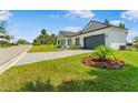 Well-maintained front yard featuring a single-story home, beautiful landscaping, and an attached two-car garage at 1006 Linkside Ct, Apopka, FL 32712