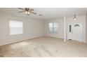 Spacious living room with neutral carpet, ceiling fan, and two windows for plenty of natural light at 10299 Cypress Knee Cir, Orlando, FL 32825