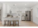 Modern kitchen featuring white cabinets, stainless steel appliances, and a breakfast bar with seating at 1030 Huntington Ct, Longwood, FL 32750
