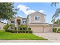 Charming two-story home with manicured landscaping, three-car garage, and a welcoming facade exuding suburban elegance at 1097 Harmony Ln, Clermont, FL 34711