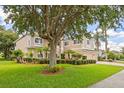 Spacious front yard with mature trees and manicured landscaping, providing shade and enhancing curb appeal at 1097 Harmony Ln, Clermont, FL 34711