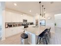 Modern kitchen with a large center island, stainless steel appliances, and sleek white cabinetry at 13993 Title Way, Winter Garden, FL 34787