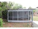 Screened-in back porch offers a view of the backyard, enclosed with lattice at the base at 16320 3Rd St, Umatilla, FL 32784