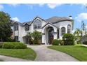 Beautiful two-story home with black trim and a well-manicured lawn and driveway at 1741 Edgewater Dr, Mount Dora, FL 32757