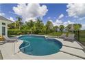 Inviting backyard pool and spa featuring a black fence and a view of the lake at 1741 Edgewater Dr, Mount Dora, FL 32757