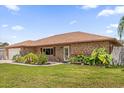 Lovely brick home with a manicured front lawn and colorful garden beds, creating inviting curb appeal at 2098 Heathwood St, Deltona, FL 32725