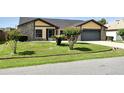 Residential house displaying an attached two-car garage and well-kept front yard and landscaping at 22 Bradford Ct, Kissimmee, FL 34758