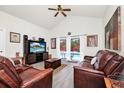 Cozy living room with comfortable leather furniture, a ceiling fan, and sliding glass doors with a pool view at 235 Hidden Springs Cir, Kissimmee, FL 34743