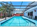 The backyard features a sparkling pool, surrounded by a screened enclosure and a patio for outdoor relaxation at 235 Hidden Springs Cir, Kissimmee, FL 34743