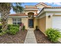 Inviting home exterior featuring a well-manicured lawn, mature landscaping, and a covered front entry at 255 Cordova Ave, Davenport, FL 33897