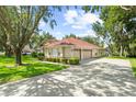 Spacious home features a long driveway leading to an attached three-car garage and lush green lawn at 2613 Breezy Meadow Rd, Apopka, FL 32712
