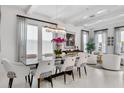 Elegant dining area featuring a modern chandelier, glass table, and white chairs at 2781 Stanfield Ave, Orlando, FL 32814
