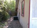 Side of house with bamboo in background, air conditioner, red trimmed windows and horizontal siding at 31429 Anna St, Deland, FL 32720