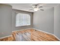 Bright bedroom with hardwood floors, ceiling fan, and a large window at 3519 Gatlin Place Cir, Orlando, FL 32812
