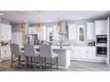 Modern kitchen featuring white cabinetry, stainless steel appliances, an island with seating, and stylish pendant lighting at 426 Veneto Cir, Clermont, FL 34715