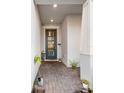 Inviting front porch featuring a blue door, brick flooring, and potted plants for a warm welcome at 4316 Foggy Oak Ln, Sanford, FL 32773