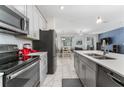 Modern kitchen with stainless steel appliances, granite countertops, and a view of the open-concept living area at 4974 Windermere Ave, Kissimmee, FL 34746