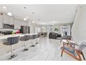 Bright, open-concept living area with sleek modern flooring and lots of natural light; bar seating is available at 4974 Windermere Ave, Kissimmee, FL 34746