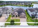 Aerial view of a single-story home with a well-kept lawn, brick driveway, beautiful landscaping and solar panels at 5029 Hartwell Ct, St Cloud, FL 34771