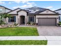 Charming single-story home with a manicured lawn, brick driveway, beautiful landscaping and solar panels at 5029 Hartwell Ct, St Cloud, FL 34771