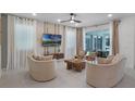 Bright living room with tile flooring, stylish furnishings, large windows, and a sliding glass door leading to the outside at 8913 Coconut Breeze Dr, Kissimmee, FL 34747