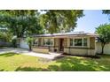 Charming home featuring stone accents, manicured lawn, and solar panels at 901 Candle Berry Rd, Orlando, FL 32825