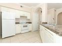 Well-lit kitchen featuring white appliances, tile flooring, and classic cabinetry at 911 N Orange Ave # 143, Orlando, FL 32801