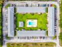Bird's eye view of apartment complex featuring a landscaped courtyard with a central swimming pool and ample parking at 1100 E Caroline St # 204, Tavares, FL 32778