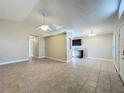 Open-concept living room with tile flooring, a ceiling fan, and a partial view of the kitchen at 1115 Naples Dr, Orlando, FL 32804