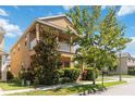 Two-story home boasts a second-floor balcony, mature trees, and manicured landscaping for curb appeal at 12255 Joshua Tree Trl, Windermere, FL 34786