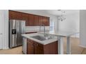 Modern kitchen featuring stainless steel appliances, an island with a white countertop, and custom cabinets at 12884 Penshurst Ln, Windermere, FL 34786