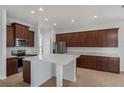 Well-equipped kitchen with an island, stainless appliances, custom cabinetry, and tiled floor at 12884 Penshurst Ln, Windermere, FL 34786