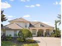 Beautiful two-story home featuring lush landscaping, a tile roof, and a welcoming front entrance at 13025 Lake Roper Ct, Windermere, FL 34786