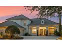 Elegant home featuring a tile roof, inviting front porch, and meticulously maintained landscaping at 13025 Lake Roper Ct, Windermere, FL 34786