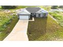 Charming gray home features an attached garage, and seeded lawn, and freshly painted white trim at 1304 Hillsborough Ct, Kissimmee, FL 34759