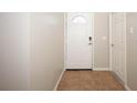 View of hallway featuring ceramic tile floor, neutral paint, and a white front door at 14130 Leicester Ln, Orlando, FL 32828