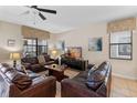 Cozy living room with comfortable leather sofas, tile flooring, and a ceiling fan at 1442 Moon Valley Dr, Davenport, FL 33896