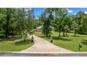 Long driveway leading to a brick home, framed by mature trees, and a mailbox at 1908 S Farm Rd, Deland, FL 32720