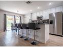 Beautiful kitchen with white cabinets, stainless steel appliances, an island with bar stool seating, and modern finishes at 2006 Stone Abbey Blvd, Orlando, FL 32828