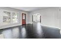 Spacious living room with original dark floors, white trim, arched doorway, and lots of light at 25 E Pinecrest Ave, Eustis, FL 32726