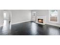 Bright living room featuring refinished floors, a brick fireplace, and abundant natural light at 25 E Pinecrest Ave, Eustis, FL 32726