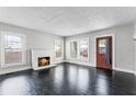 Inviting living room with a fireplace, refinished hardwood floors, and windows for natural light at 25 E Pinecrest Ave, Eustis, FL 32726