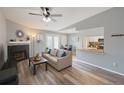 Inviting living room with hardwood floors, modern ceiling fan, fireplace, and dining area access at 2550 Alafaya Trl # 9303, Orlando, FL 32826
