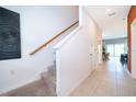 Hallway with tiled floors, stairs with carpet, and a door leading into the dining room and kitchen at 2596 Penguin Blvd, Davenport, FL 33837