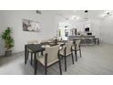 Bright dining room with modern table and chairs next to an open-concept kitchen and white walls at 2978 Stillwater Dr, Kissimmee, FL 34743